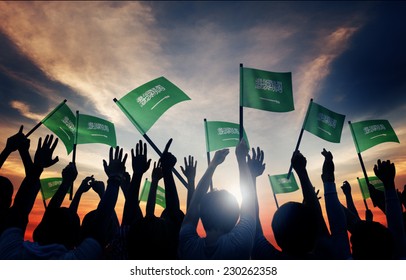 Silhouettes Of People Holding Flag Of Saudi Arabia