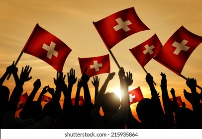 Silhouettes Of People Holding Flag Of Switzerland