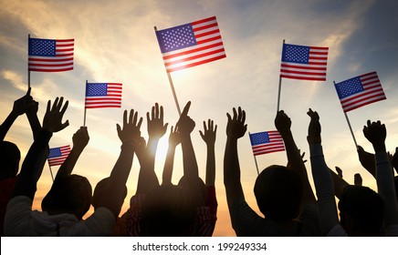Silhouettes of People Holding the Flag of USA - Shutterstock ID 199249334