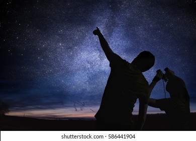 Silhouettes of people observing stars in night sky. Astronomy concept.