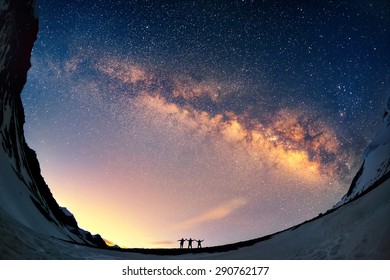 Silhouettes Of The People Standing Together Holding Hands Against The Milky Way In The Mountains. 