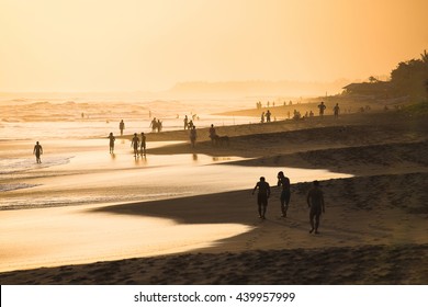 Silhouettes of people at sunset on Kuta beach in Bali, Indonesia