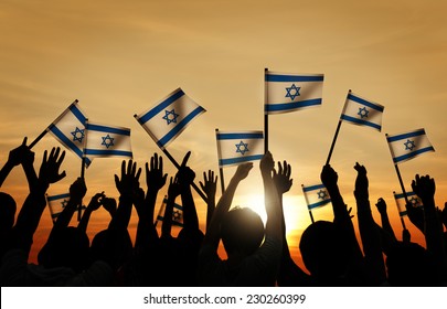 Silhouettes Of People Waving The Flag Of Israel