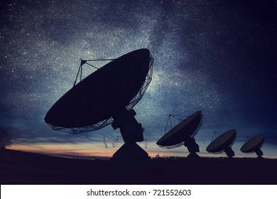 Silhouetten von Satellitenschüsseln oder Radioantennen am Nachthimmel. Weltraumbeobachtungsstelle.