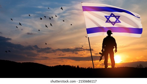 Silhouettes of soldiers with Israel flag and flying birds against the sunrise in the desert. Concept - armed forces of Israel.