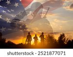 Silhouettes of a soldiers with USA flag against the sunset. Veterans Day, Memorial Day concept