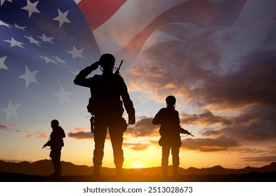 Silhouettes of a soldiers with USA flag against the sunset. Veterans Day. Honoring All Who Served