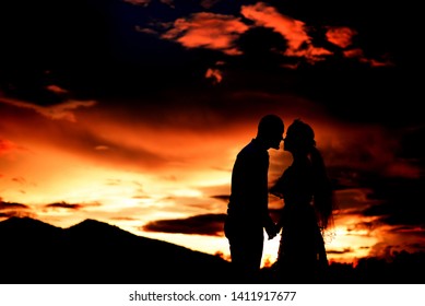 Silhouettes at sunset with bride and groom