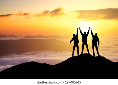 Silhouettes of team on mountain peak. Sport and active life concept