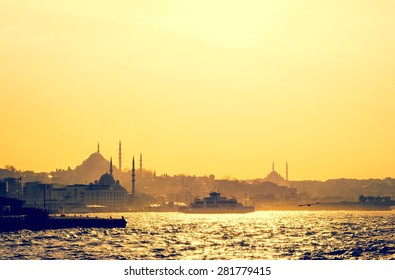 Silhouettes of turkish steamboat and minaret of mosque in Istanbul on sunset. Skyline with soft light effect - travel concept in retro style. Cityscape of old town in a fog, Istanbul seaside.