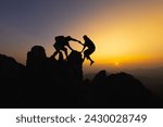  Silhouettes of two people climbing on mountain and helping. Teamwork of two men hiker helping each other on top of mountain climbing team beautiful sunrise. Help and assistance concept. 