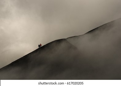 Silhouettes Of Two People Hiking Mount Bromo - Active Volcano In Java, Indonesia