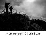 Silhouettes of two women with backpacks on an autumn mountain hike