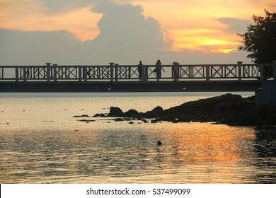Silhouettes of two women staring at the sunset from a bridge in Perhentian Islands, Malaysia. Travel destination, contemplation concept