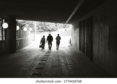 Silhouettes Of Unrecognizable Construction Workers Walking In A Tunnel