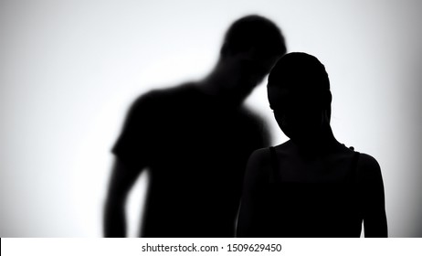 Silhouettes of upset woman and man together, experiencing life difficulties