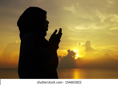      silhouettes of a women praying during sunset                          