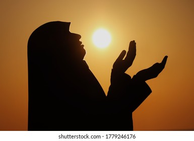 silhouettes of a women praying during sunset