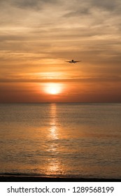 Silhoutte Of The Passenger Airplane In The Air And Sunset In Background