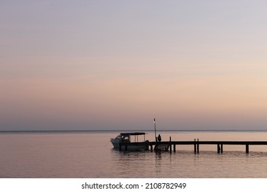 A Silhoutte Of Small Boat With Its Captain In A Small Jetty At Ora Beach Eco Resort, Indonesia