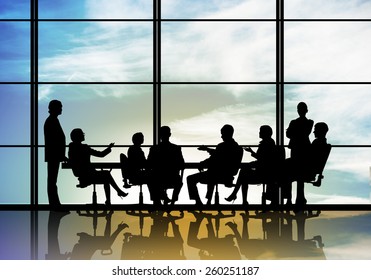 Silhouttes Of Business People As Team Sitting Round Table