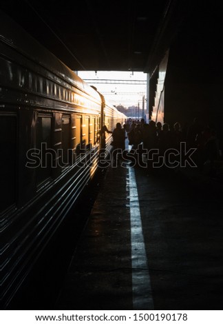 Silhuettes of people walking into the train - bright sunset