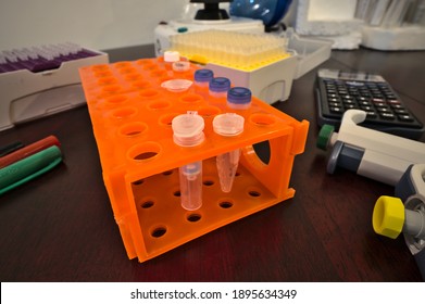 Silica Column And Eppendorf Tube On A Rack Surrounded By Laboratory Materials; Biochemistry And Molecular Biology Lab Bench