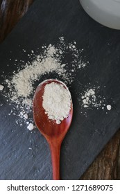 Silica White Powder On Wooden Spoon On Black Background 