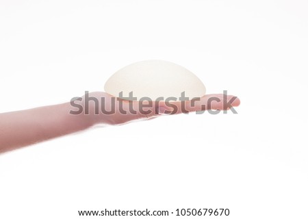Silicone breast implant on hands 

