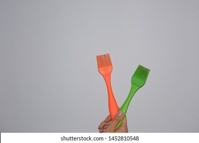 silicone kitchen utensils in hands on a light background