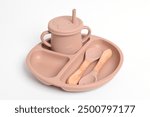 Silicone tableware set. Silicone plate, cup, spoon, fork. Baby tableware on white background. Serving baby food, kid dishware. First baby food concept