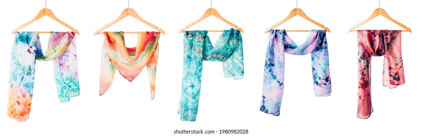 Silk colourful hand painted tied scarves hung on hangers over white background. Woman fashion, tying a scarf, wearing a scarves. Stylish ways to tie and wear scarves - Shutterstock ID 1980982028