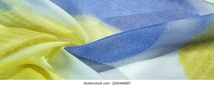 silk fabric in soft blue, yellow and white tones with abstract patterns and bed tones. Texture, pattern, collection - Shutterstock ID 2245446807