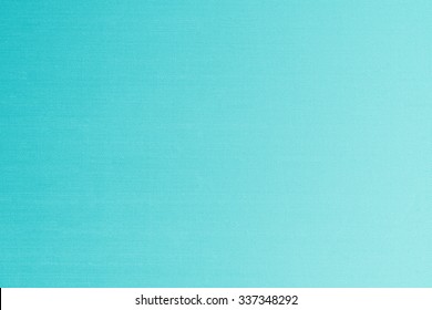 Silk fabric wallpaper texture detail background in shiny cyan blue green turquoise color 