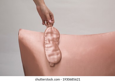 Silk pillow and woman with sleep mask on gray background, soft luxury cushion. Pleasant sleep concept - Shutterstock ID 1930685621