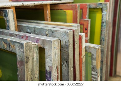 Silk screen printing screens stored in a wooden rack ready for printing. - Shutterstock ID 388052227