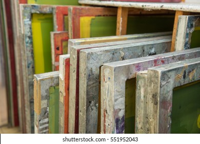 Silk screen printing screens stored in a wooden rack ready for printing. - Shutterstock ID 551952043