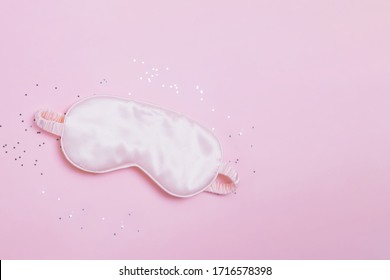 Silk Sleeping Mask And Small Confetti Stars On Pink Background, Top View