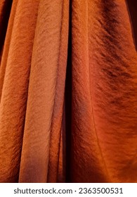 Silk velvet fabric in a background color of burnt orange for use in crafts, fashion, and decoration Stockfoto