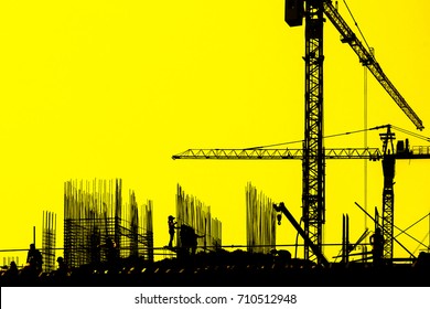 The Sillhouette  Of Workers And  Construction Site, Tower Cranes With Yellow Sky /background,construction Site Shadow 