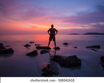 Sillouette Man On The Rock In The Sea With Sunset