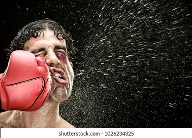 silly boxer man takes a punch in the face isolated on black.funny concept portrait - Shutterstock ID 1026234325