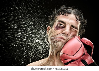 silly boxer man takes a punch in the face isolated on black.funny concept portrait