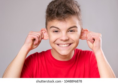 Silly Boy Making Grimace - Funny Monkey Face. Child With Big Ears, Isolated On White Background. Emotional Portrait Of Caucasian Teenager Looking At Camera.