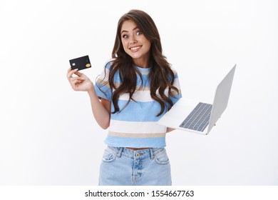 Silly Cute Happy Woman Smiling Joyfully, Shrugging And Gazing Camera Explain How Easy Use Online Banking, Hold Laptop And Credit Card, Recommend Shop Online, Stand White Background Joyful