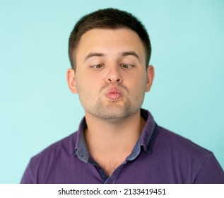 Silly Man. Ridiculous Face. Playing Fool. Clueless Guy In T-shirt Shifting Eyes To Nose Looking Squint Pouting Lips Isolated Blue.