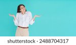 Silly mistake. Close up of cute girl saying sorry, shrugging shoulders and smiling with oops face expression, standing over blue background