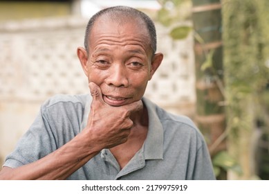 A silly old man puts the edge of his palm to his chin. Known locally as Mr Pogi pose, a lighthearted declaration of being handsome.. - Shutterstock ID 2179975919