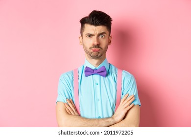 Silly Young Guy With Moustache, Sulking And Feeling Timid, Cross Arms On Chest, Being Offended At You, Standing Insulted On Pink Background