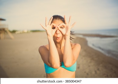 Silly young woman grimacing and having fun on the beach enjoying summer vacation holiday.Happy woman making funny face,having fun at party.Pulling funny faces.Humorous woman making someone laugh - Powered by Shutterstock